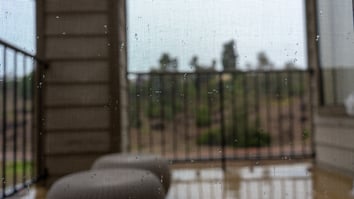 Blurred view of a rainy day from a balcony, illustrating how bad weather affects the vacation rental guest experience.